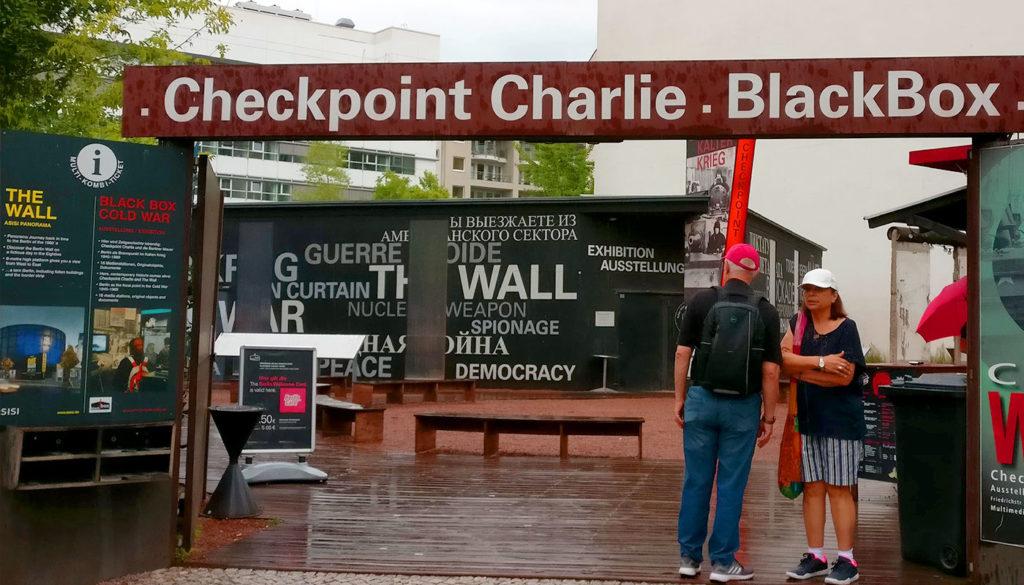 Kaksi turistia seisoo Checkpoint Charlien turistikohteessa.