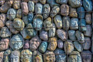 kivestä kaiverrettuja eri värisiä kasvoja rautaisessa häkissä päällekkäin kasattuna. Gulakkien uhrien muistomerkki Moskovasta.