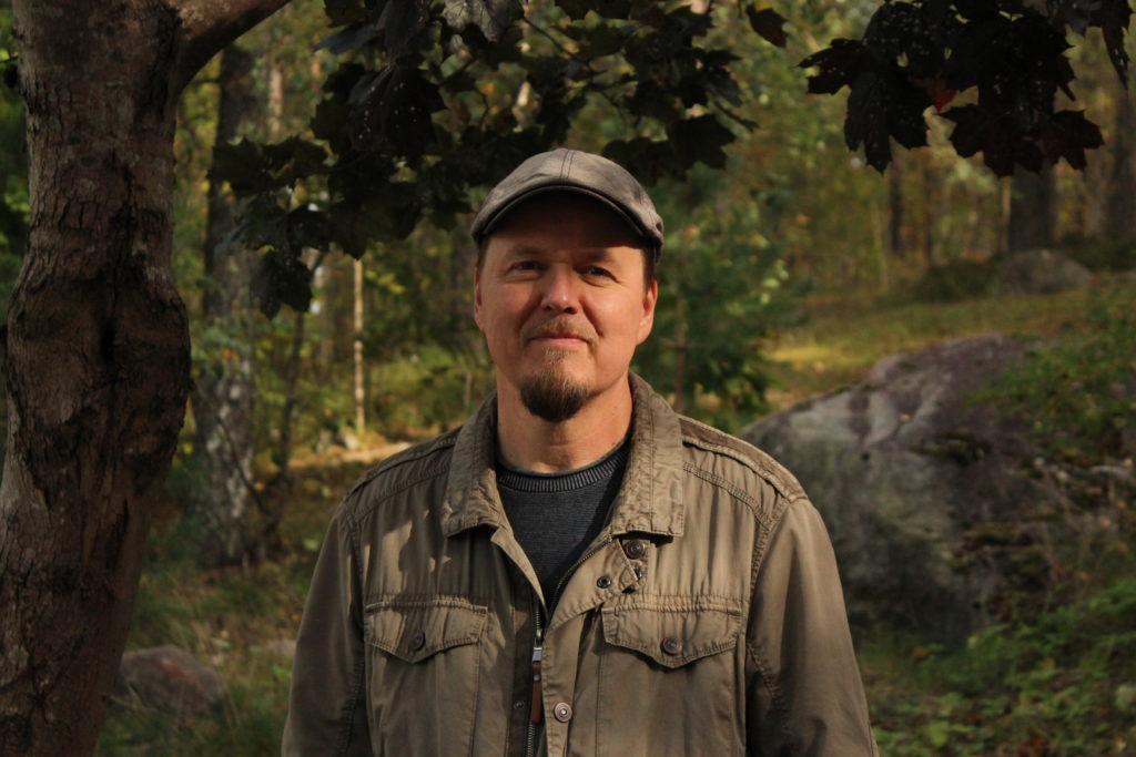 Marko Haimilahti kuvassa etualalla. Taustalla metsämaisemaa.