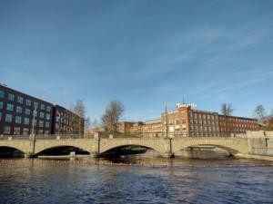Tammerkoski, Tampere. Kuvassa Stakunnankadun silta, taustalla tehdasrakennuksia ja Tampellan kyltti.