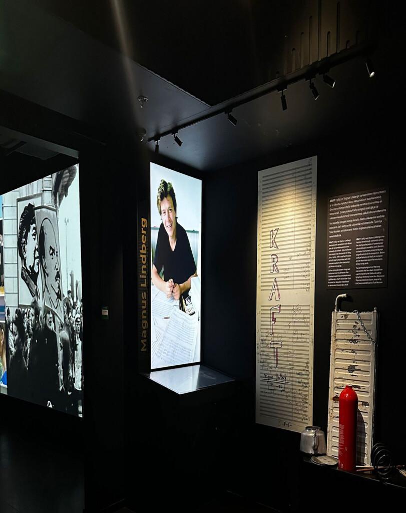 pimeässä museotilassa henkilön kuva projisoituna seinälle